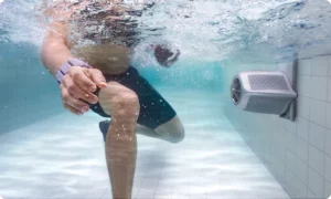 Plavec cvičí proti proudu JetSwim namontovanému na stěně bazénu