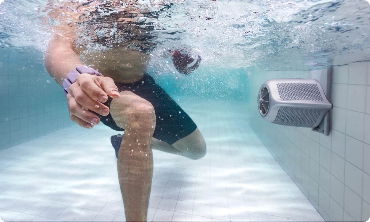 Plavec cvičí proti proudu JetSwim namontovanému na stěně bazénu